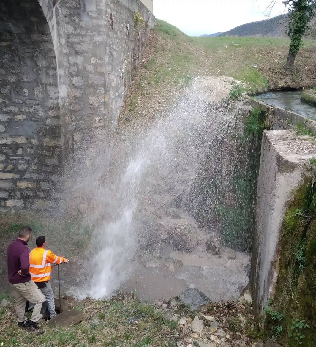Technicien communal en intervention sur une fuite du réseau d’eau potable, à proximité d’un canal de dérivation agricole de la rivière Drôme – deux usages majeurs de l’eau dans la vallée.