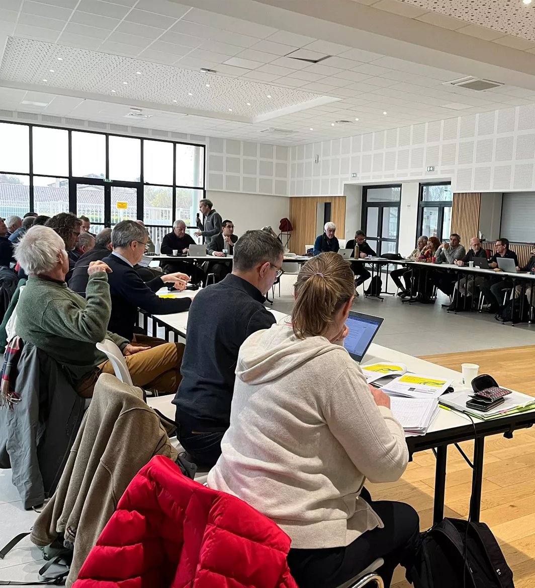 Réunion plénière de la Commission locale de l’eau avec une trentaine de participants réunis autour de tables en U dans une salle communale.
